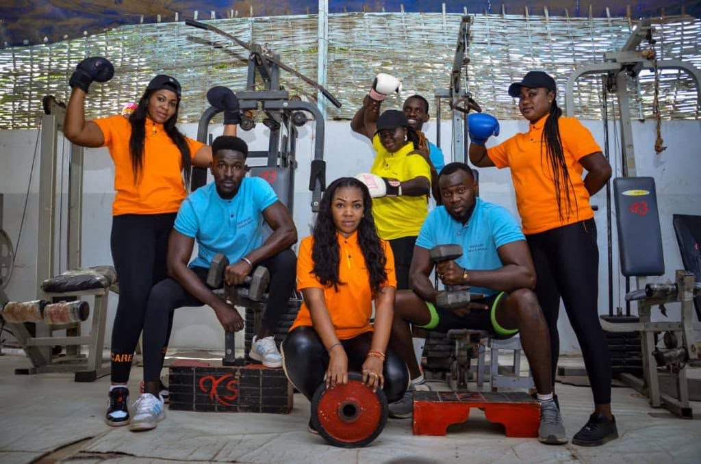 L'équipe KEB'SPORT posant avec gants de boxe et haltères dans la salle